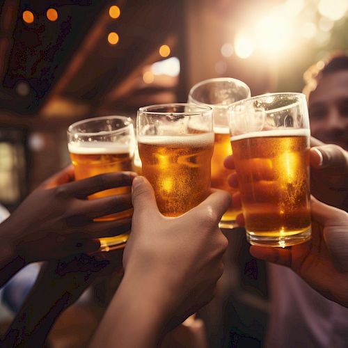 A group of people clinking glasses of beer in a celebratory toast, with warm lighting and a festive atmosphere.