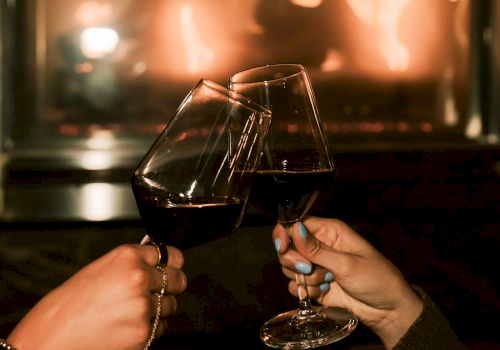 A woman smiles while playing guitar and singing into a microphone, surrounded by glowing lights and a lively atmosphere.